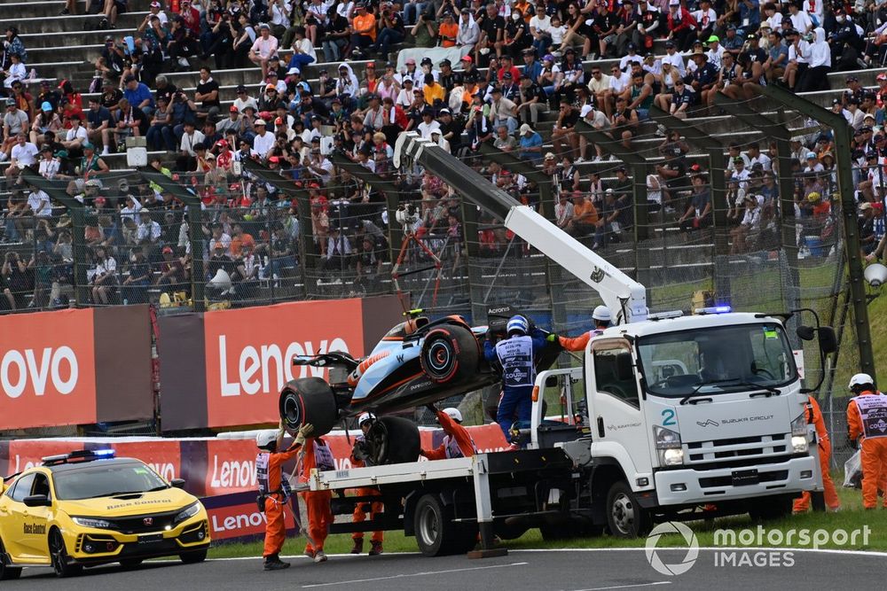 Marshals remove the damaged car of Logan Sargeant, Williams FW45, from the circuit after a crash in Q1