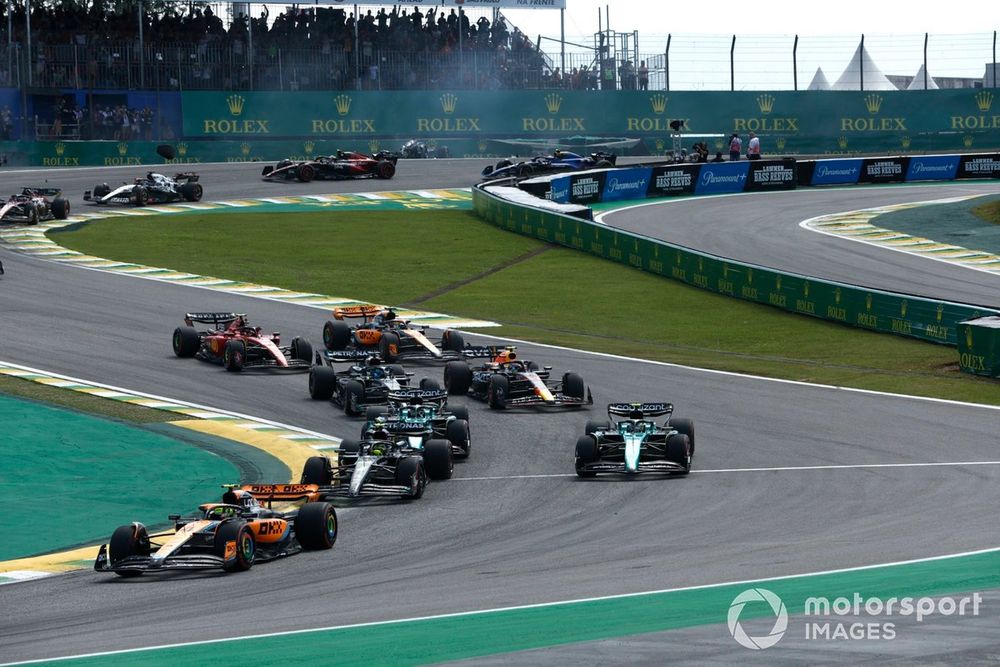 Lando Norris, McLaren MCL60, Lewis Hamilton, Mercedes F1 W14, Fernando Alonso, Aston Martin AMR23, the rest of the field at the start as Alex Albon, Williams FW45, Kevin Magnussen, Haas VF-23, crash in the background