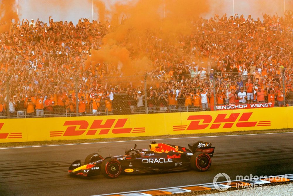 Max Verstappen, Red Bull Racing RB18, 1st position, waves from his cockpit as fans turn the air orange in celebration of victory