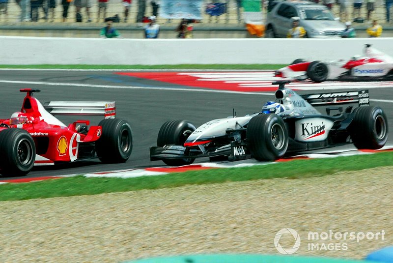 Kimi Raikkonen,  McLaren Mercedes MP4/17 runs wide,  Michael Schumacher,  Ferrari F2002 pass